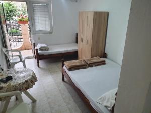 a room with two beds and a table and a chair at Apartmani Lalo Jankovic in Sutomore