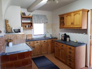 a kitchen with wooden cabinets and a window at Dom na Ponidziu z basenem in Wiślica