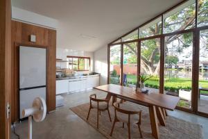 una cucina e una sala da pranzo con tavolo e sedie in legno di Nutnicha river house a Lam Phaya