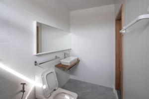 un bagno con un water bianco e un lavandino di Nutnicha river house a Lam Phaya Altre 65 foto