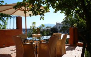 Una mesa con sillas y una sombrilla en un patio. en Dar Rass El Maa, en Chefchaouen