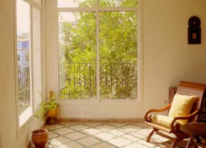 an empty room with a window and a chair and a clock at Dar Rass El Maa in Chefchaouen