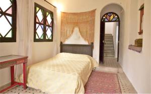 1 dormitorio con cama, ventana y escalera en Dar Rass El Maa en Chefchaouene