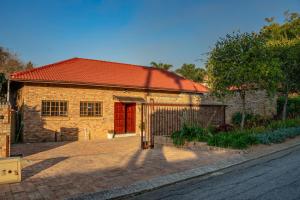 a brick building with a red door on a street at Bottle Brush Place WITH SOLAR in Roodepoort