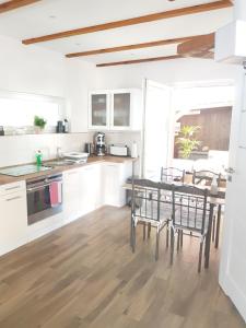 a kitchen with white cabinets and a table and chairs at Ferienhaus am Rande des Müritz-Nationalparks in Kargow