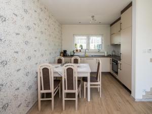 a kitchen with a table and chairs in a room at Ferienhaus Sieroslaw polnische Ostsee mit Kamin in Sierosław