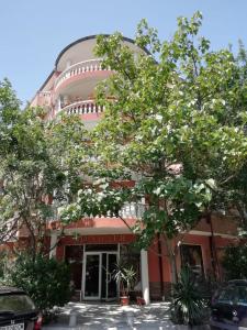 a large building with trees in front of it at Guest House Orchidea in Pomorie