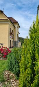 einen Garten mit Bäumen und Sträuchern vor einem Haus in der Unterkunft Pension Pod Lipou in Loučovice