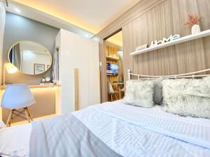 a bedroom with a white bed and a mirror at Will’s Place @ Shore2 Residences Mall of Asia in Manila