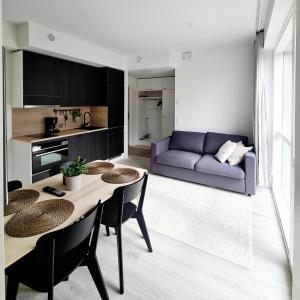a living room with a table and a purple couch at Uusi viihtysä 4-hengen loma-asunto hiekkasärkillä in Kalajoki