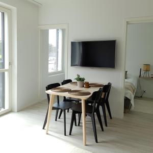 a dining room with a table and chairs and a tv at Uusi viihtysä 4-hengen loma-asunto hiekkasärkillä in Kalajoki