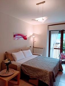 sypialnia z dużym łóżkiem i stołem w obiekcie Lake Como View Apartement Allegro w mieście Acquaseria