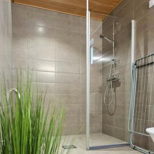 a shower with a glass door in a bathroom at Uusi viihtysä 4-hengen loma-asunto hiekkasärkillä in Kalajoki