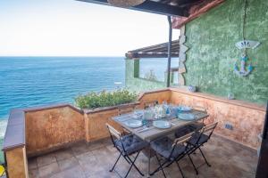 einen Tisch und Stühle auf einer Terrasse mit Meerblick in der Unterkunft Porto Corallo Frontemare in Villaputzu