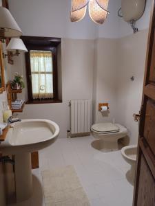 a bathroom with two sinks and a toilet and a window at Daniela B&B Affittacamere in Castiglione di Garfagnana