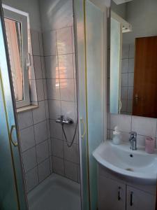 y baño con ducha y lavamanos. en Apartmani Stanković en Podaca
