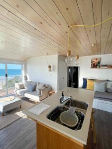 een keuken met een wastafel en een woonkamer bij Just Relax & in Boat Harbour