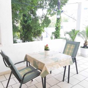 a table and chairs on a patio with a table and a plant at Guesthouse MM in Dubrovnik