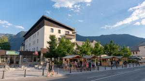 a group of people walking down a street in a town at Hotel Alp in Bovec