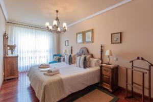 ein Schlafzimmer mit einem großen Bett und einem Kronleuchter in der Unterkunft La casa del mercadillo, Haro in Haro