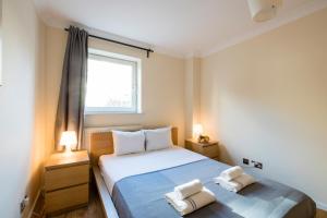 伦敦Royal London Apartments的一间卧室，床上有两条毛巾