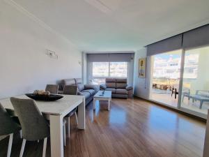 een woonkamer met een tafel en een bank bij G&G Isla Marina Puerto in Benalmádena