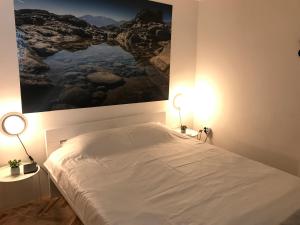 a bedroom with a bed with a painting on the wall at Beach House Valerija in Rovanjska