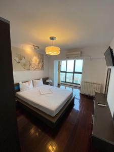 - une chambre avec un lit et une grande fenêtre dans l'établissement Magic Blue Sea, à Constanţa