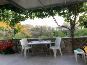 a table and chairs on a patio with a stone wall at Apartments Mirian in Petrovac na Moru