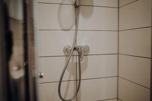 a shower with a hose attached to a white tiled wall at Ferienwohnung Alte Wäscherei II in Kitzingen +16 photos