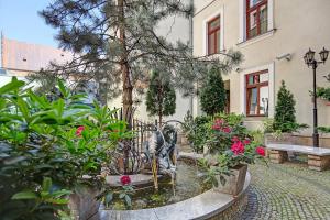 un jardin avec une fontaine en face d'un bâtiment dans l'établissement Hotel Wawel, à Cracovie