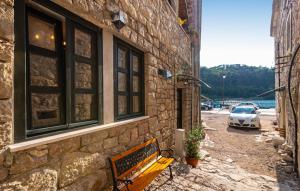 un banco sentado junto a un edificio de piedra con un coche en Villa Eximia Novigrad, en Novigrad (Dalmacia)