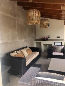 a living room with a couch and two chandeliers at Finca Clos in Borrassá