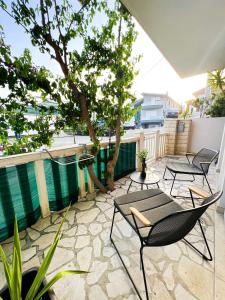 eine Terrasse mit Stühlen, einem Tisch und einem Baum in der Unterkunft SanOne-Studio apartment in Jesenice