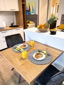 einem Holztisch mit zwei Teller Essen drauf in der Unterkunft SanOne-Studio apartment in Jesenice