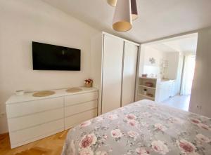 a bedroom with a bed and a dresser with a tv at Apartmani Marko in Tučepi
