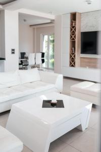 uma sala de estar branca com sofás brancos e uma mesa em Villa Dea em Kotor
