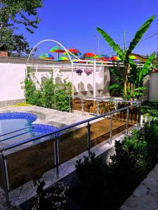 une piscine avec parasols dans un complexe hôtelier dans l'établissement Qafqaz Fountain House, à Qabala