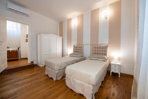 1 Schlafzimmer mit 2 Betten und einer Kommode mit 2 Lampen in der Unterkunft Mamo Florence - Cherubini Apartment in Florenz