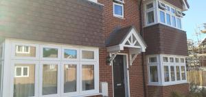 una casa de ladrillo con ventanas blancas y una puerta en Beautiful En-suite room en Wokingham