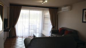 a living room with a couch and a table and a window at Blue Lagoon Hotel and Conference Centre in East London