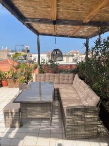 a patio with a table and couches on a roof at Follow The Sun Catania - Rooftop Terrace in Catania