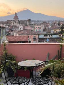 カターニアにあるFollow The Sun Catania - Rooftop Terraceの市街の景色を望むバルコニー(テーブル、椅子付)