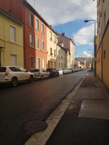 a street with cars parked on the side of the road at Le Progrès in Villeurbanne