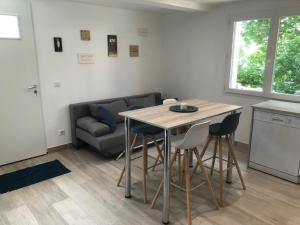 uma sala de estar com uma mesa e cadeiras e um sofá em L'escapade em Saint-Léger-les-Mélèzes