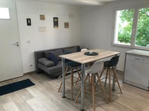 sala de estar con mesa, sillas y sofá en L'escapade en Saint-Léger-les-Mélèzes