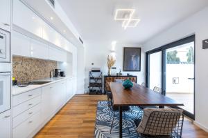 cocina con armarios blancos y mesa de madera en Medusa Luxury Marina, en Vilamoura