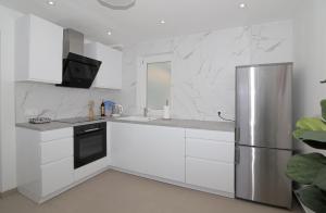een keuken met witte kasten en een roestvrijstalen koelkast bij Seaside Apartment M Zaton 3 -SeaView and Parking in Zaton