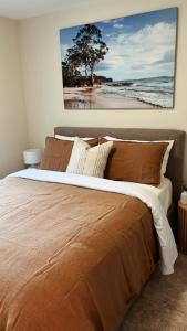 um quarto com uma cama com um quadro na parede em Adventure Bay Holiday Home em Adventure Bay