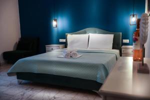 una camera blu con un letto e un asciugamano sopra di Waves Studios a Chrisi Ammoudia